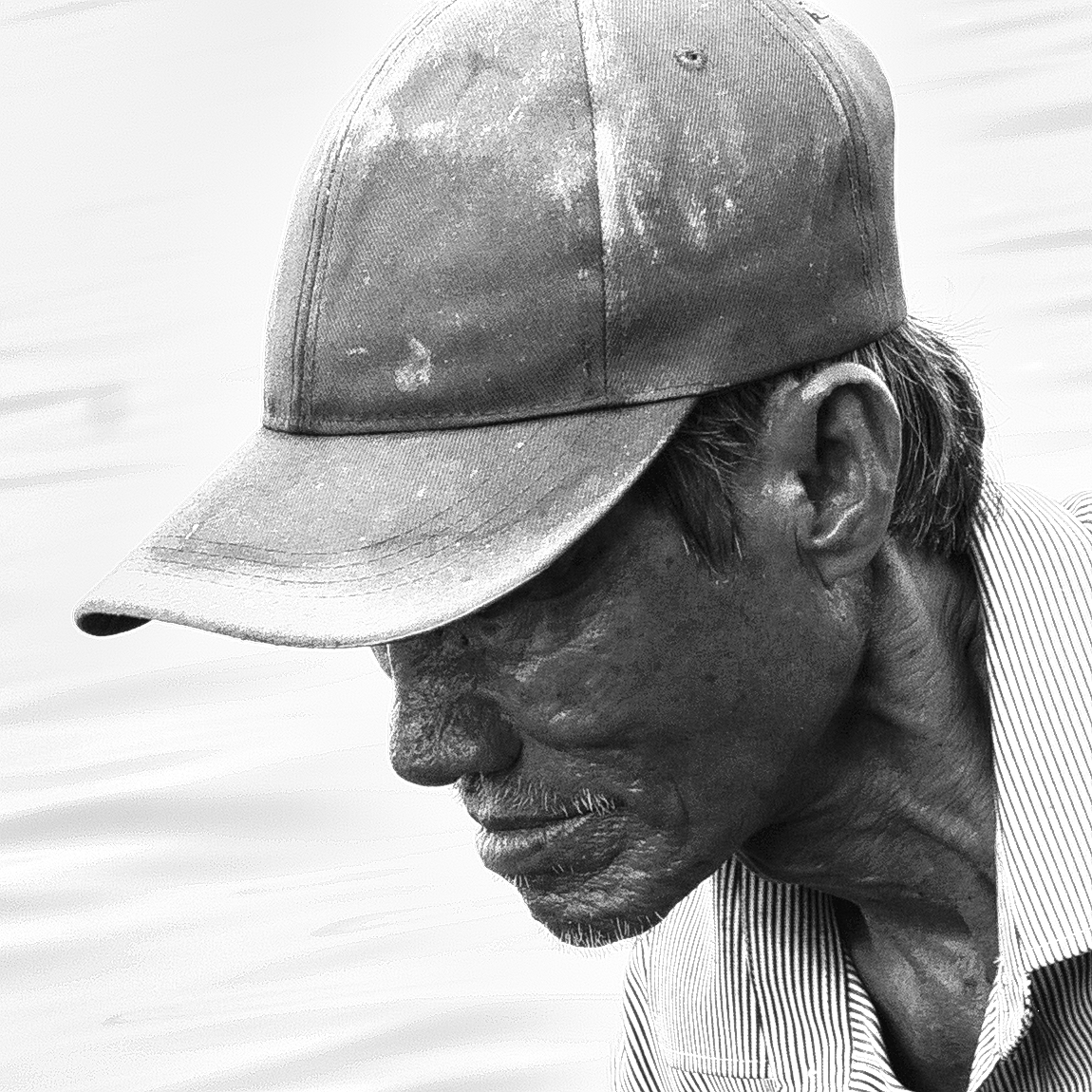 black and white headshot image of a fish farmer intent on his nets