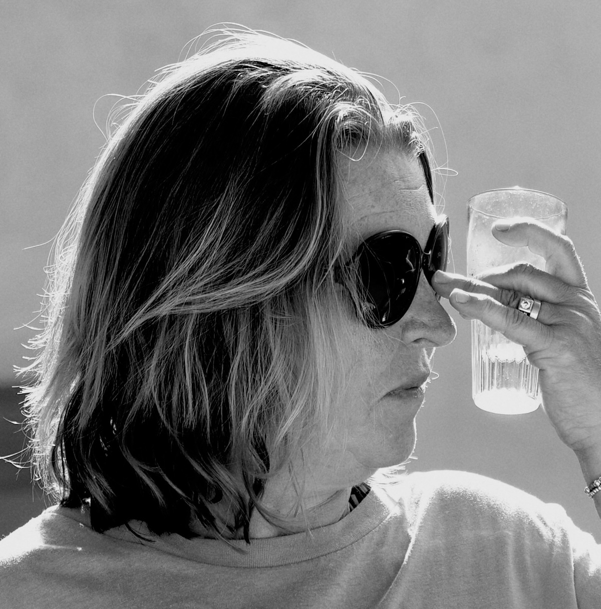black nd white side-on image of a woman holding a cooling drink