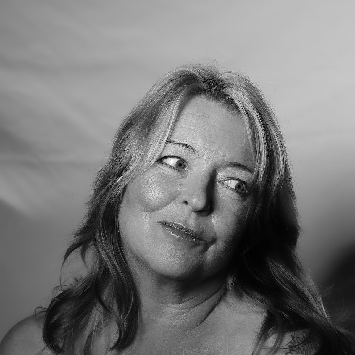 Black and white photograph in potrait style of a woman glancing to one side