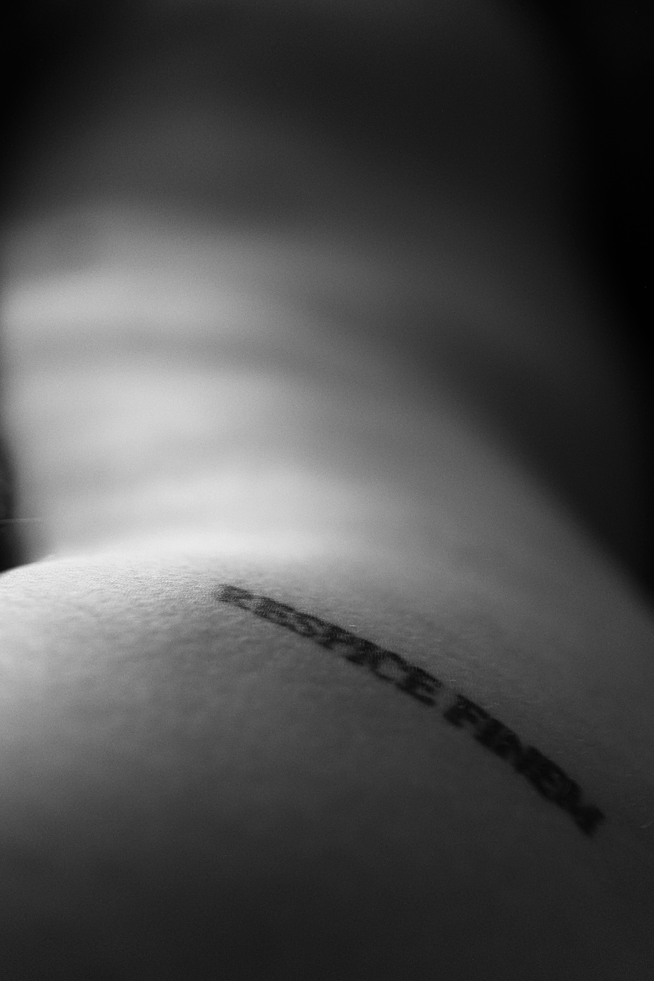 Naked woman's side with Respice Finem tattoed on her hip