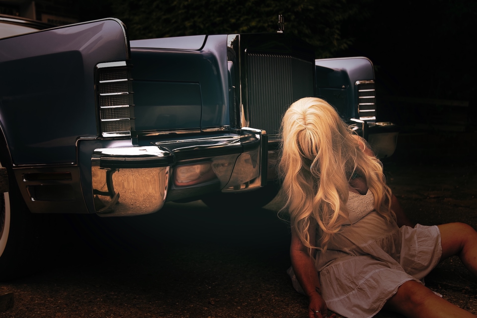 block busted blond woman slumped against an old america limo