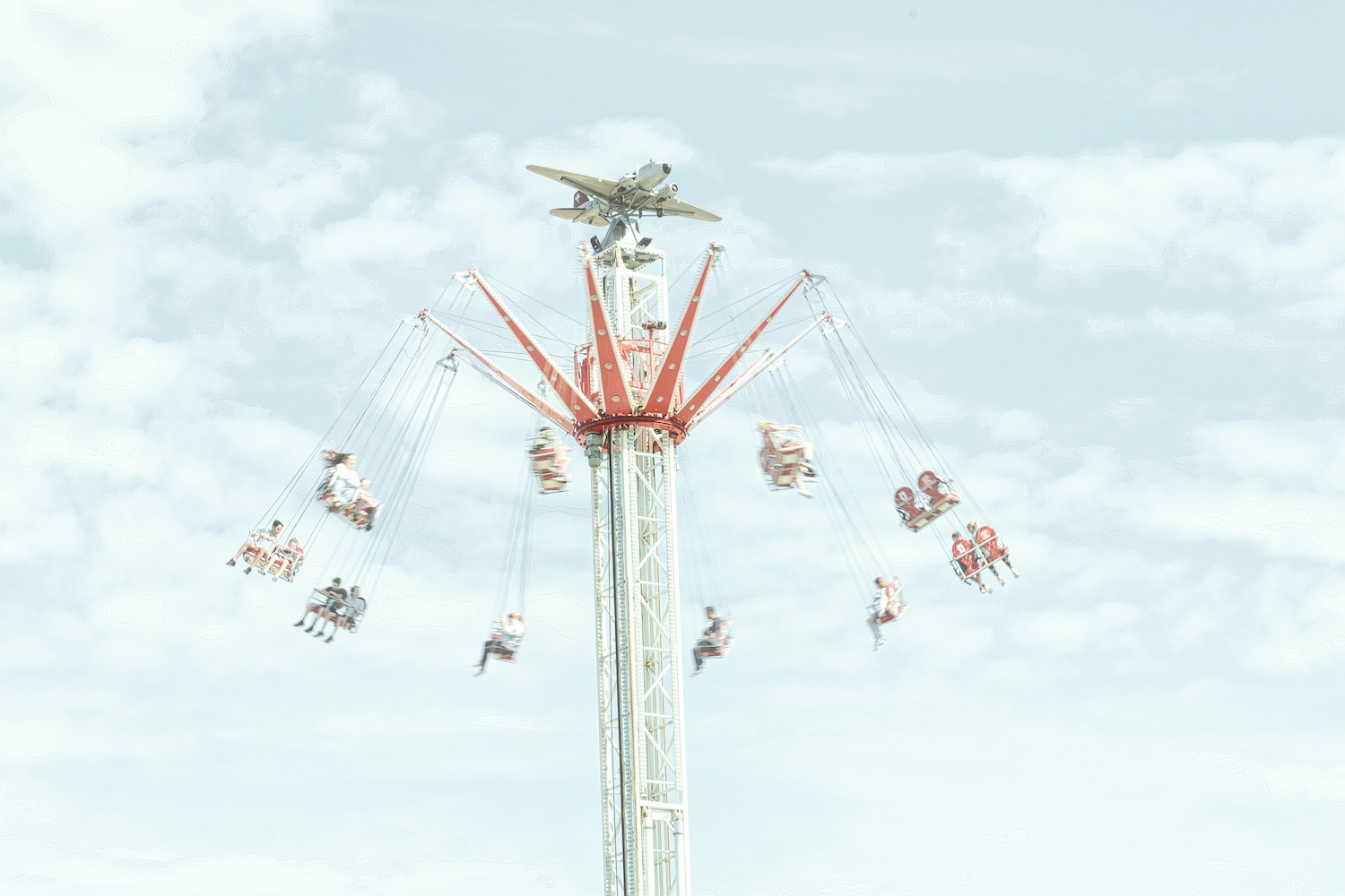 Fairground swing at full heigh and spinning people
