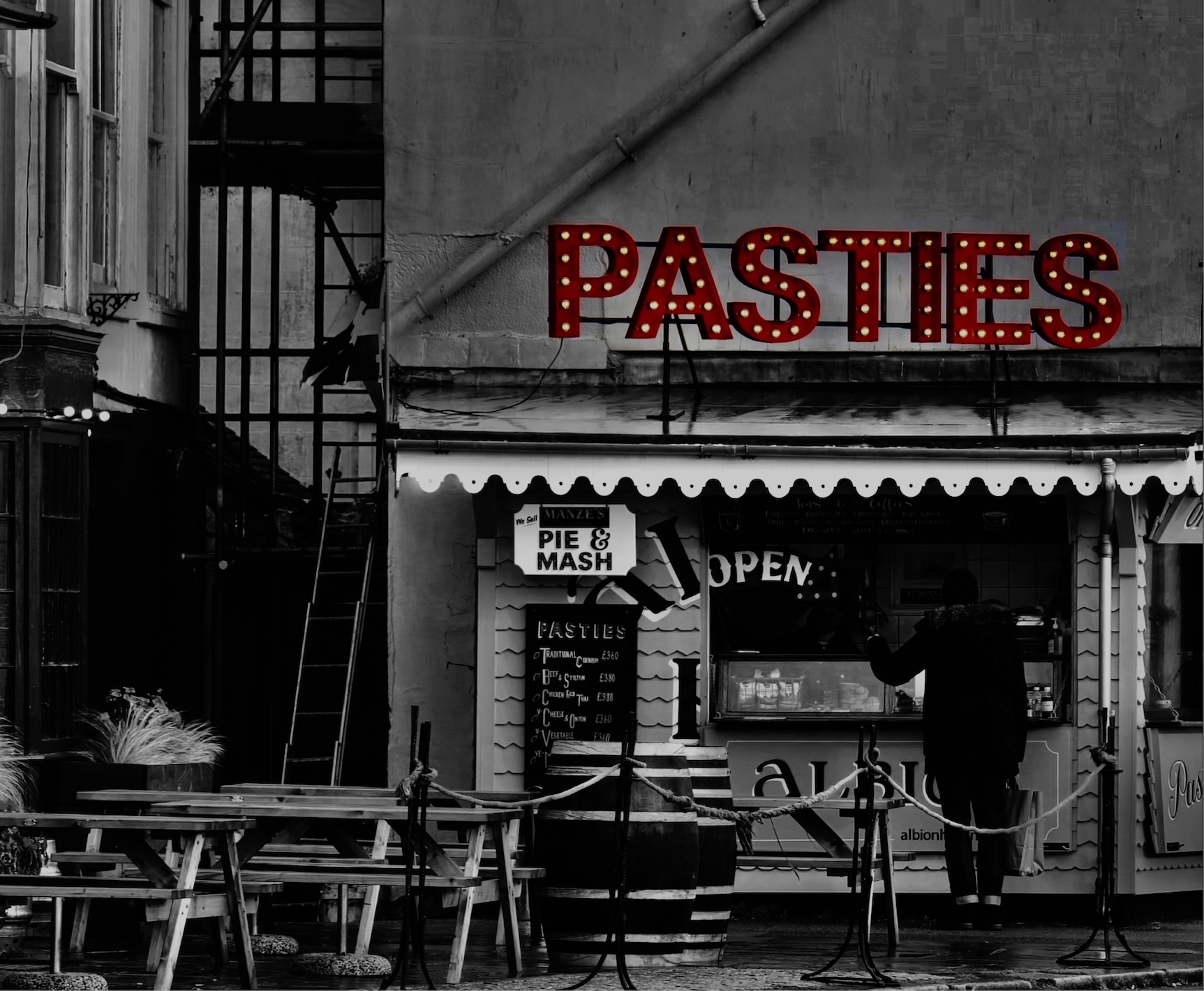 The famous Pasties stall written up with light bulbs against a black and white background