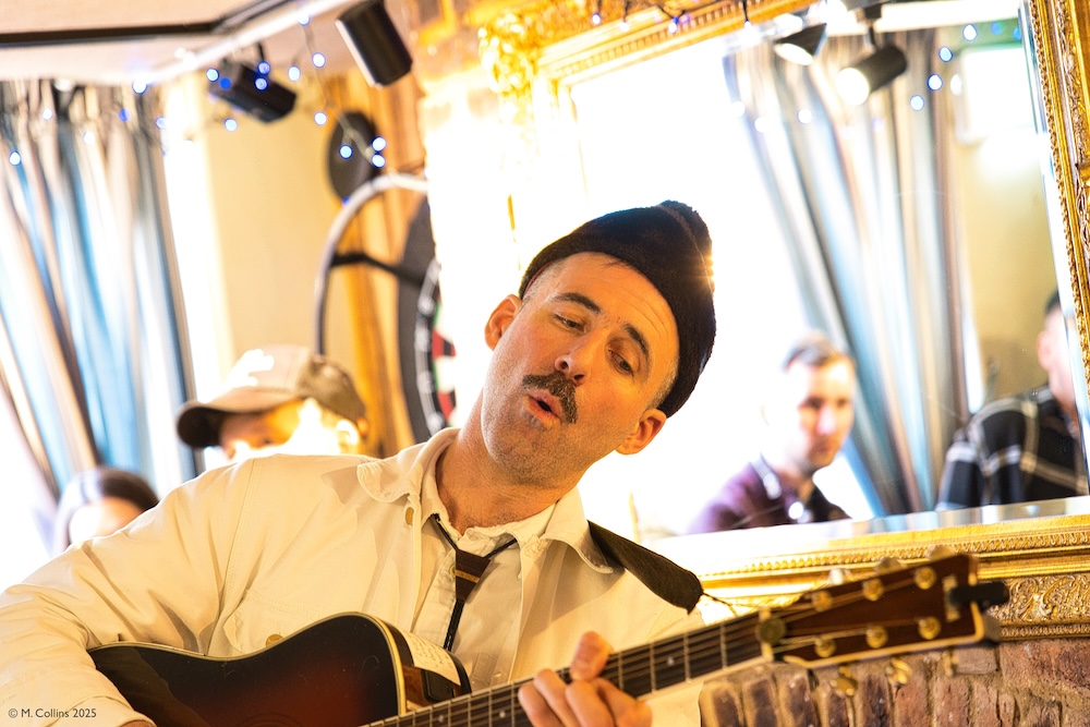 James Brute singin and playing guitar at the Fat Tuesday music festival