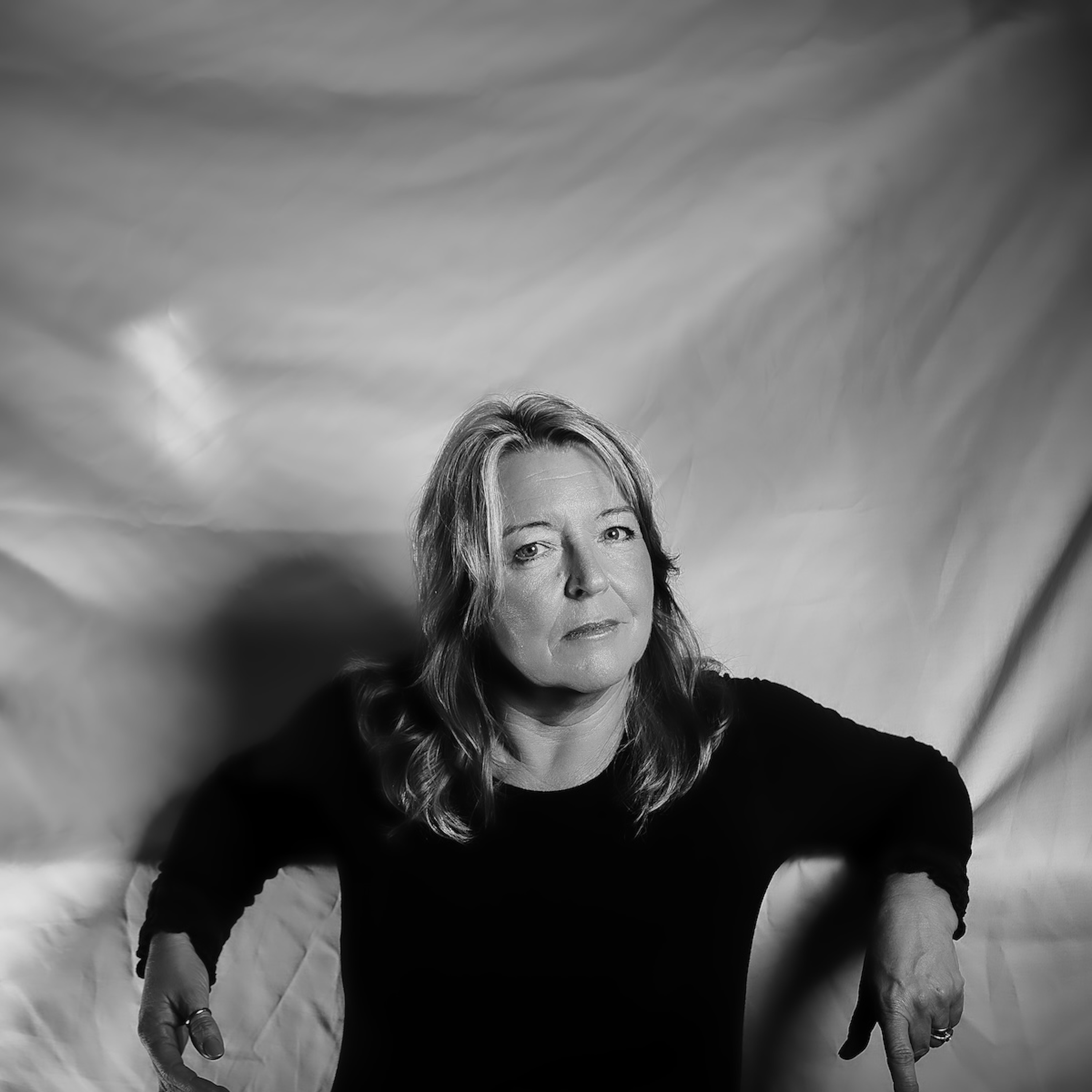 black and white portrait of a woman leaning back on her elbows